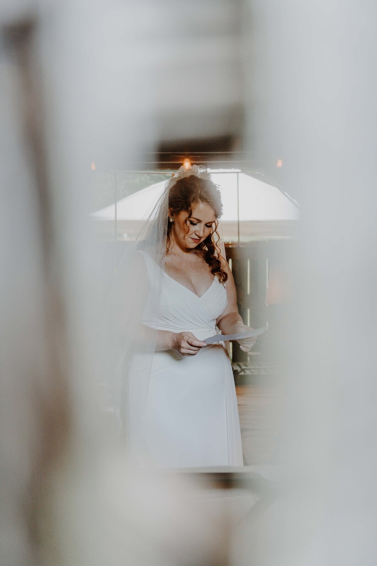 bride reading over her vows secretly before reading them out loud