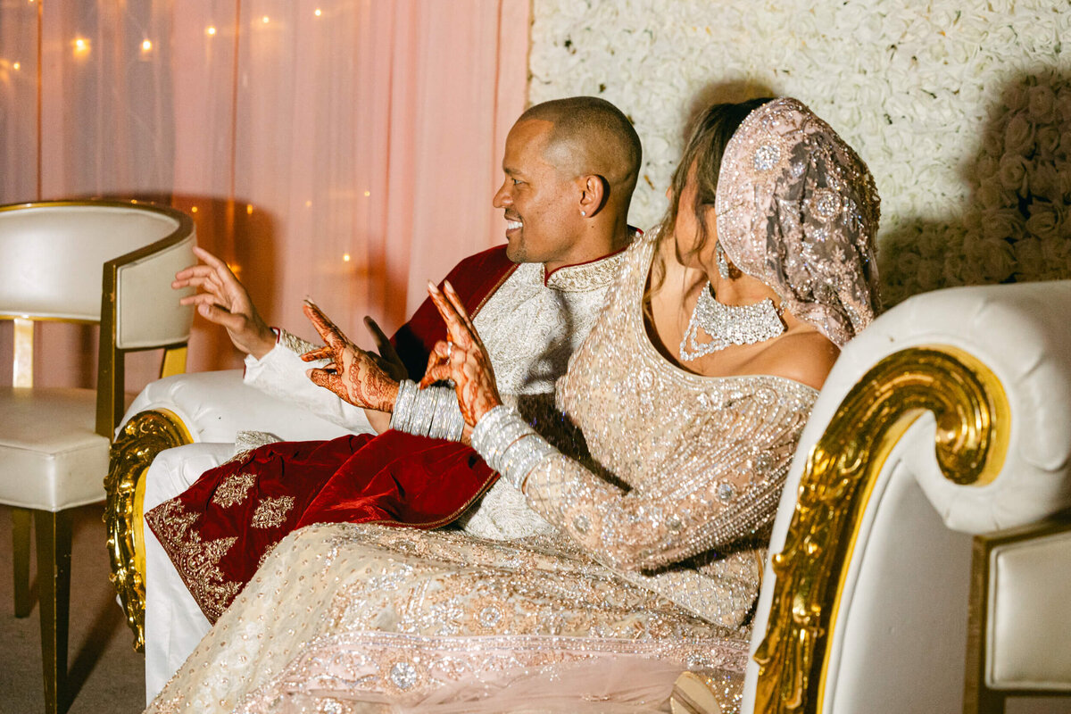 A candid wedding photo fo the bride and groom sitting beside each other dancing in Dublin Ireland