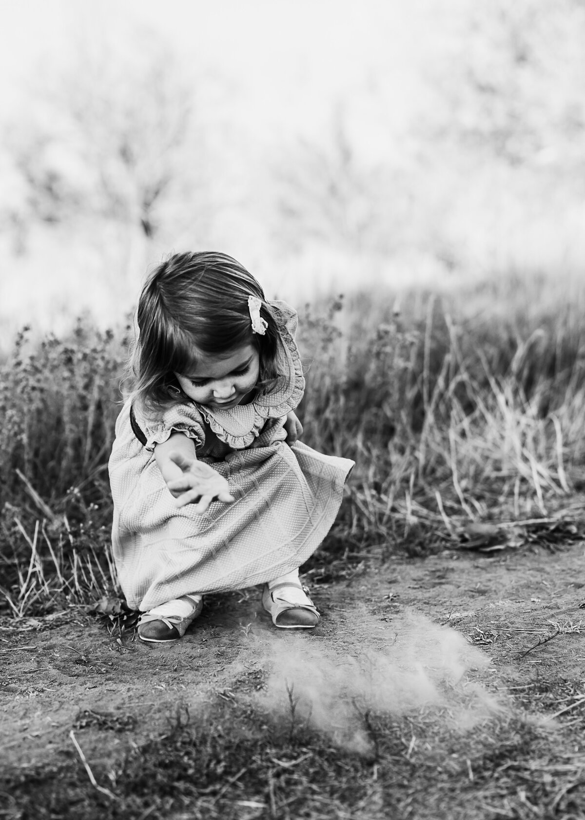 toddler girl plays in dirt at sunset in a field in Arvada Colorado