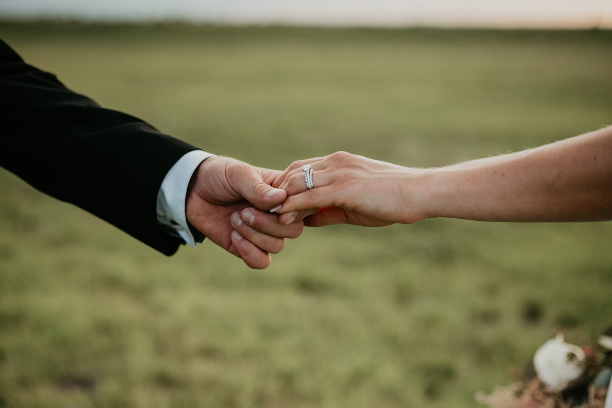 bride and groom holding hands, wedding rings, , Emily wheeler photography