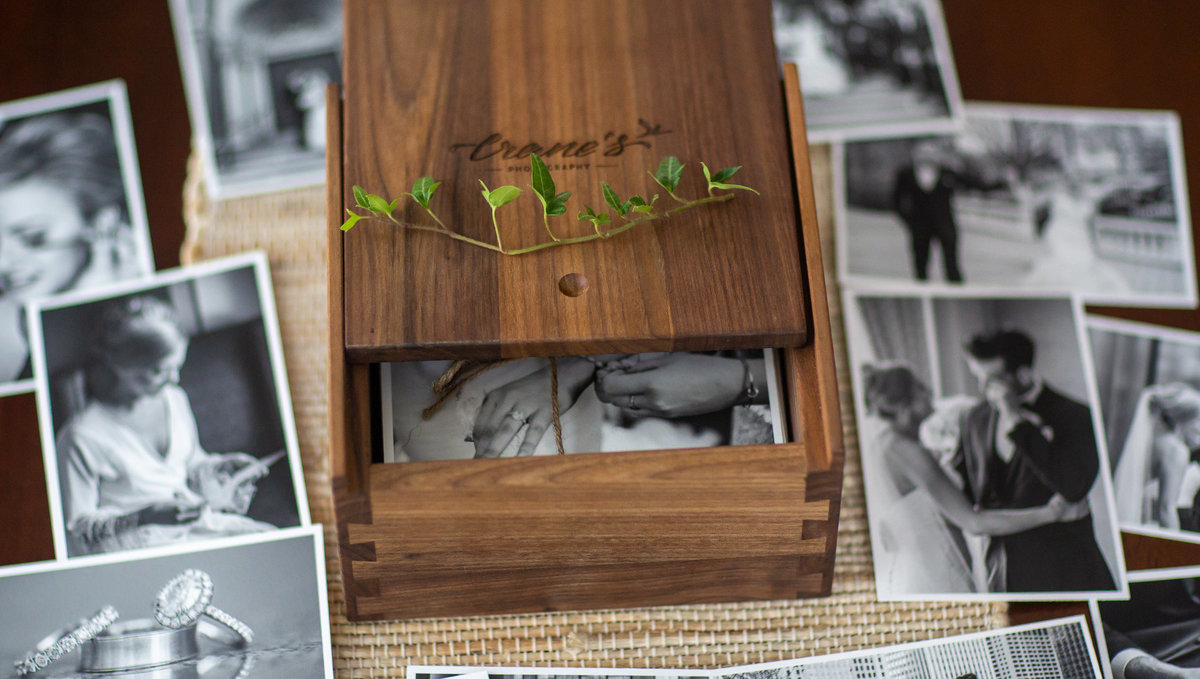 Wooden keepsake wedding box with images  spread around it.