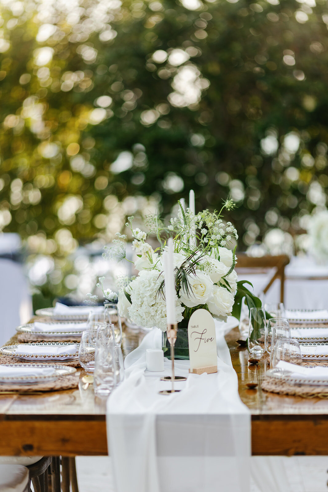 Chic wedding tablescape with tropical floral arrangements at La Siesta Marina Resort.