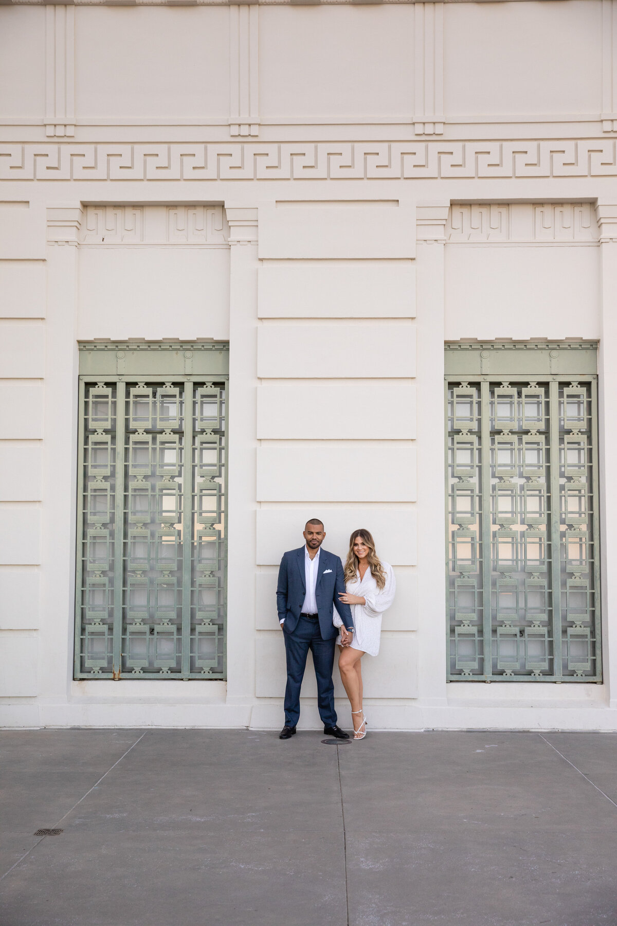 couple leaning on a white wall