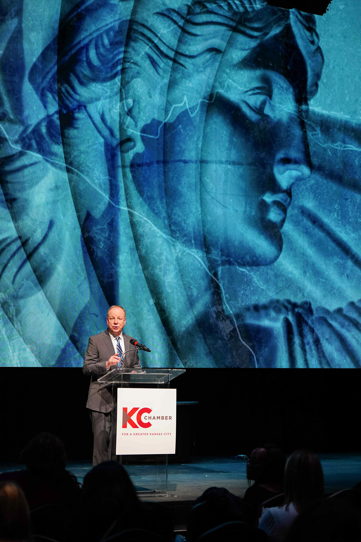 kansas-city-event-photography-0042-man-speaking-on-stage-with-blue-screen