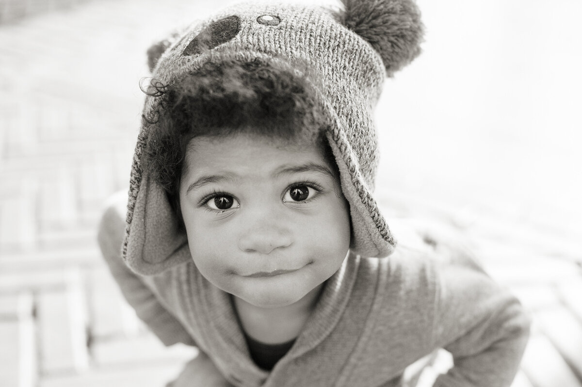 A small child looking up with a koala beanie on 