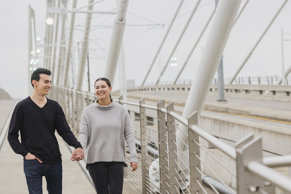 Two people walk hand in hand at their engagement.
