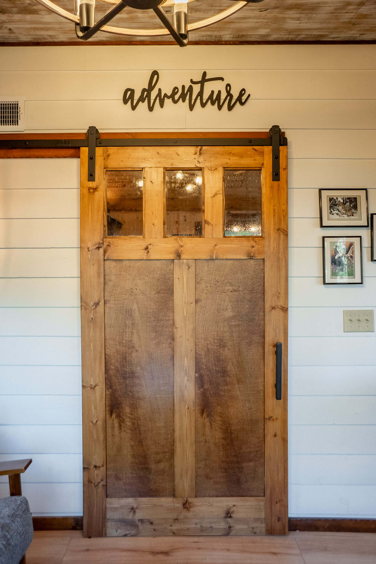 Handmade barn door with adventure lettering in luxury cabin
