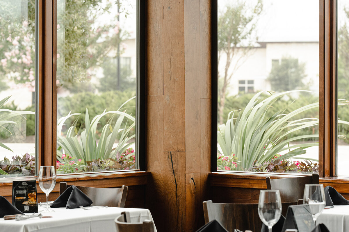 Wood paneling next to large windows with natural light into restaurant interior design