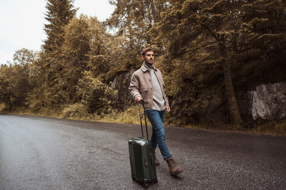 Male model walking through Norway with suitcase Duifhuizen