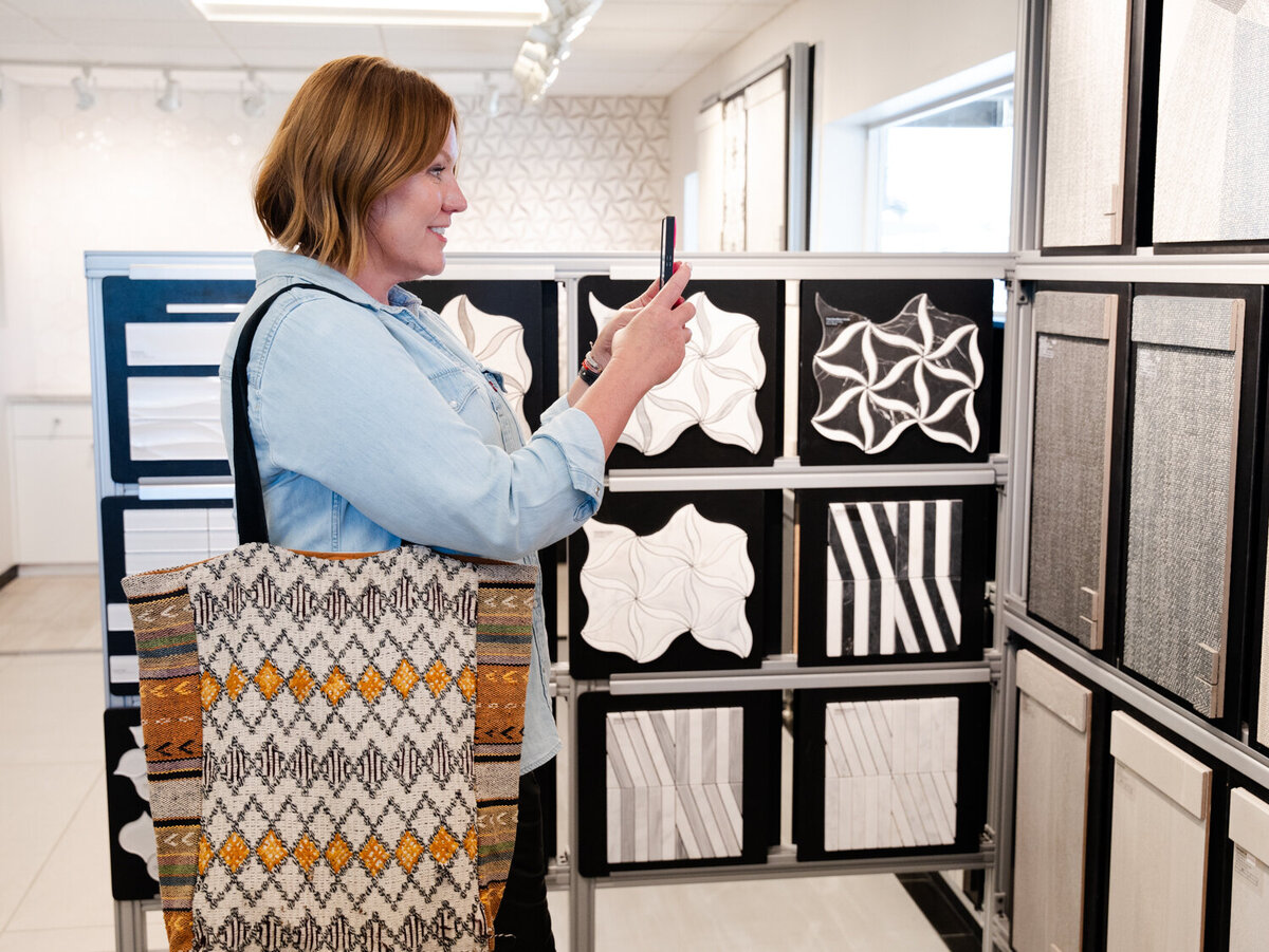 Project manager at a tile store taking a picture of a tile display