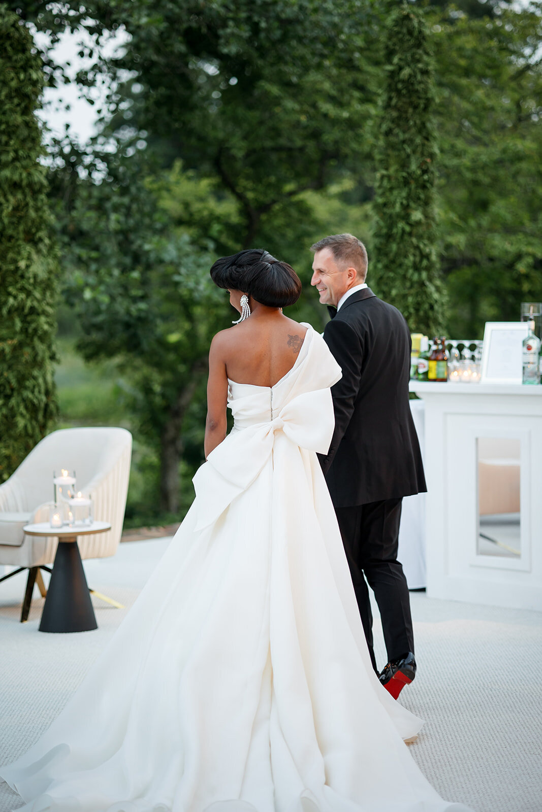 Bride and groom sharing a quiet moment by the reception tables.