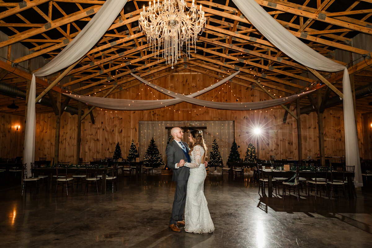 Bride and groom dancing together in an empty reception hall