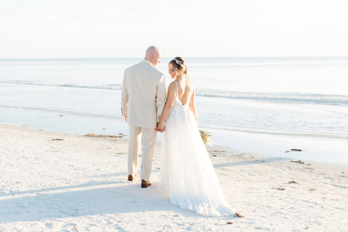 bride and groom walking by the ocean shore