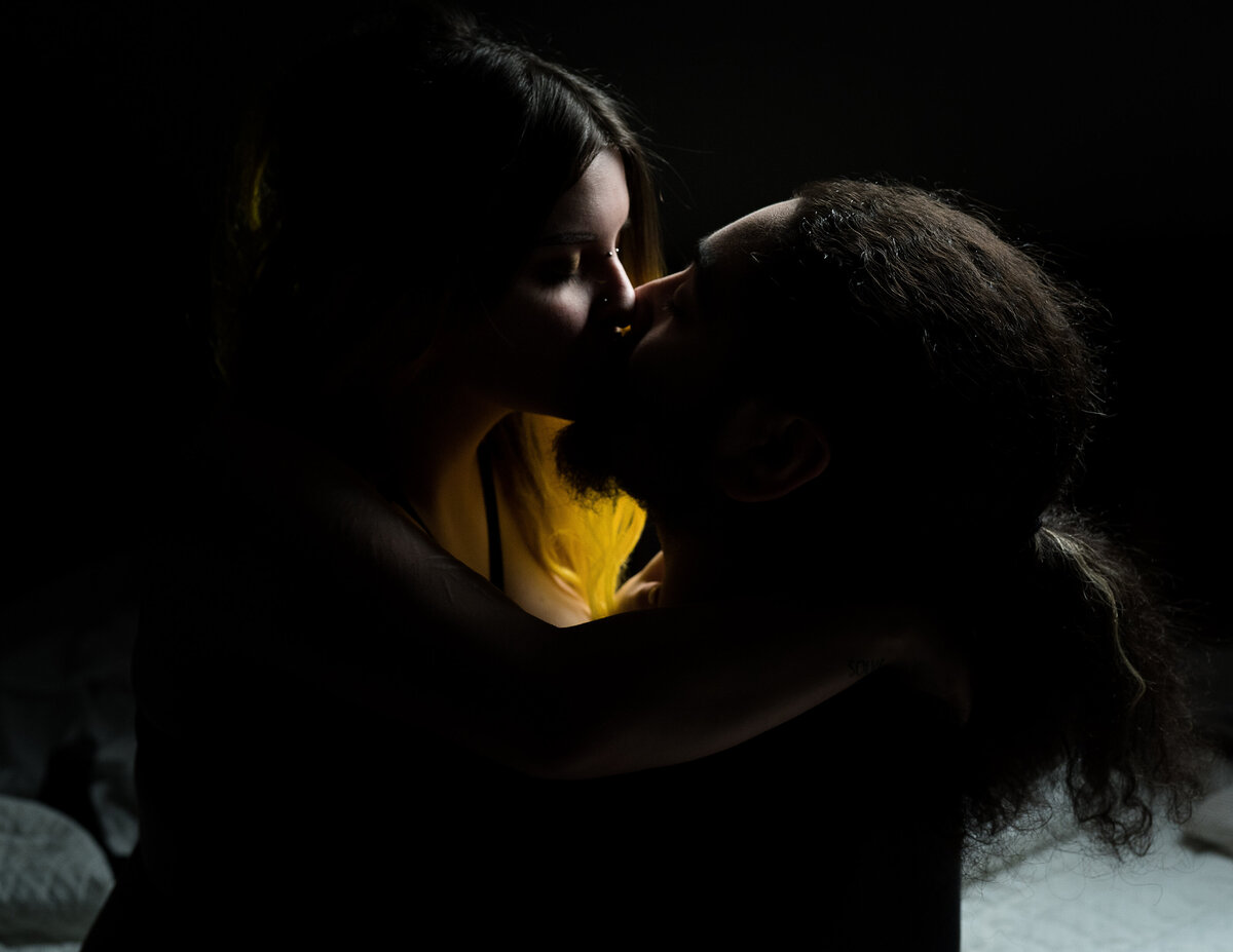 A couple kissing in a dramatic image.