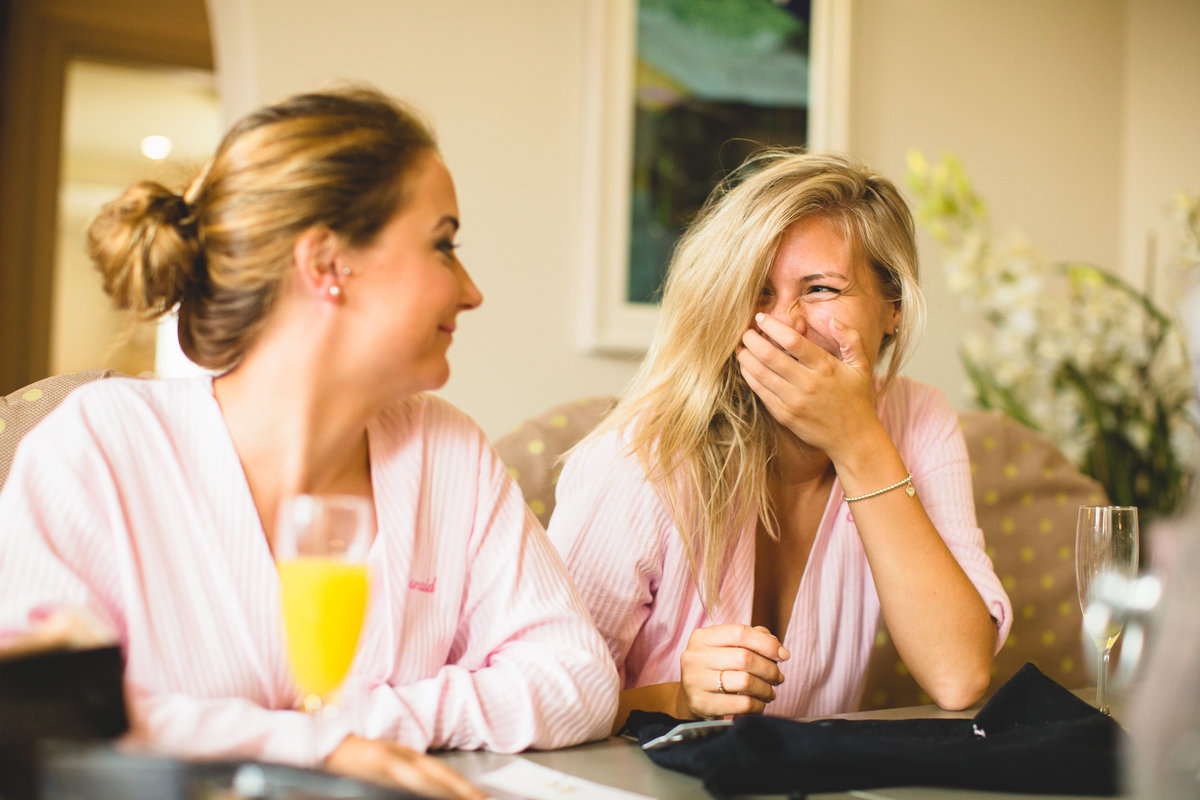 bride in pink dressing gown laughing with bucks fizz