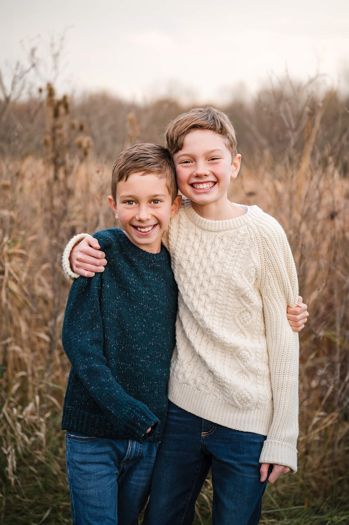 Siblings posing for a photo in the middle of a field at lefurge woods nature preserve