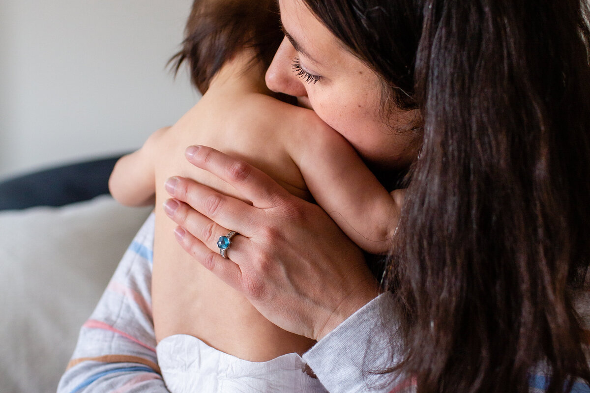 Detail shot of sweet snuggle between mother and baby.