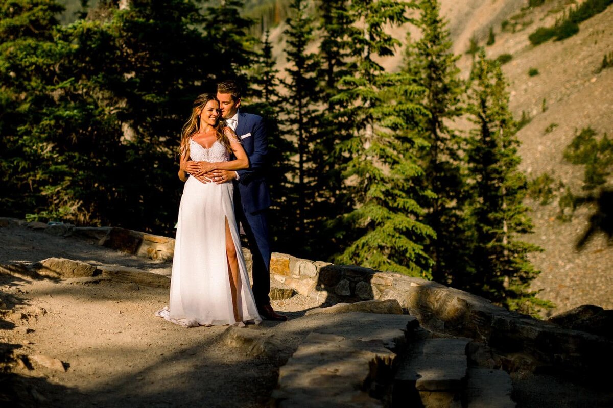 Moraine-Lake-Alberta-elopement-with-bride-and-groom-walking-towards-the-lake