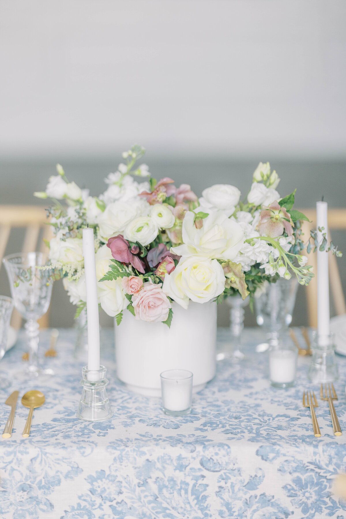 beautiful table setting with blue table cloth and white and pink flower bouquet