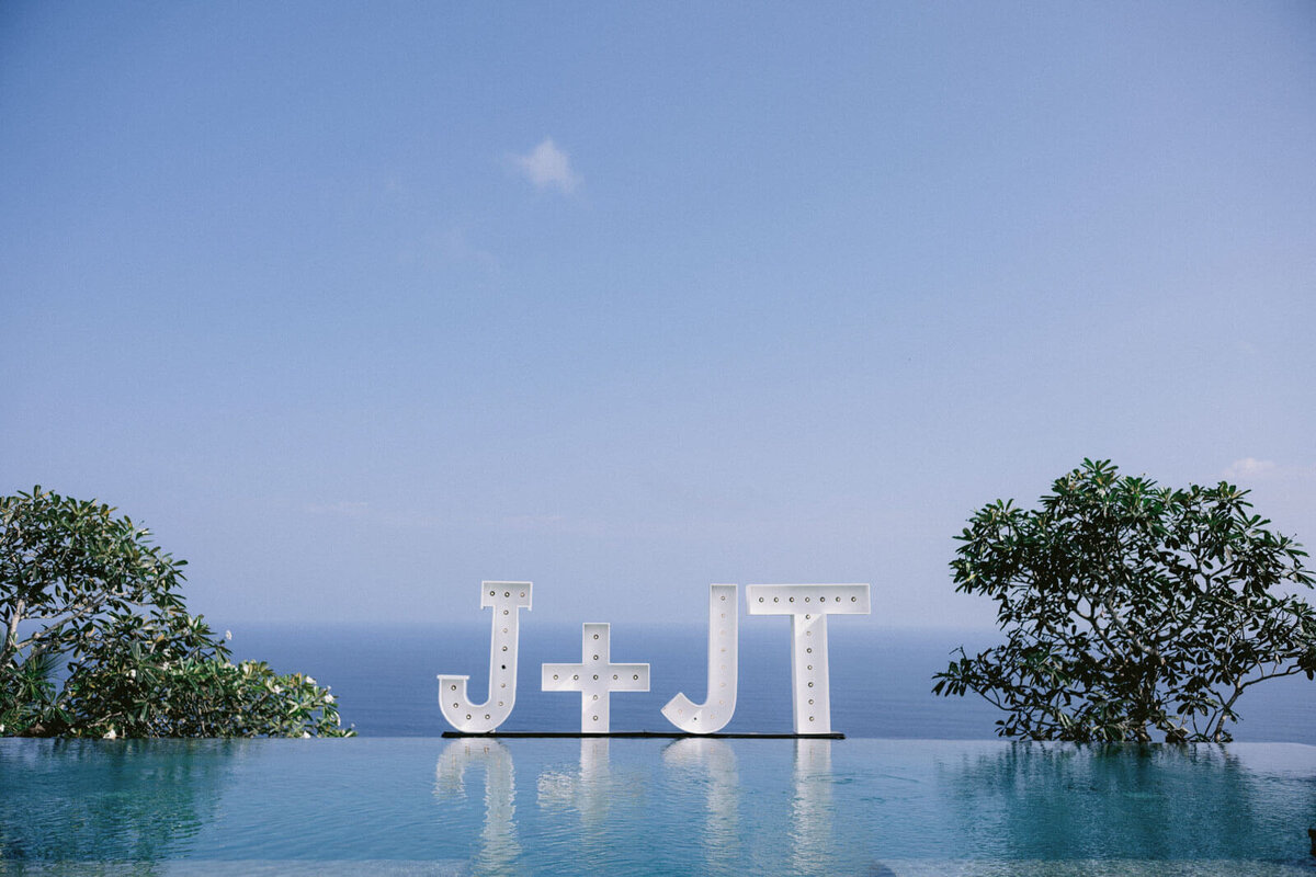Large letters, J+JT, are on the edge of the pool for the wedding in Khayangan Estate, Bali, Indonesia. Image by Jenny Fu Studio