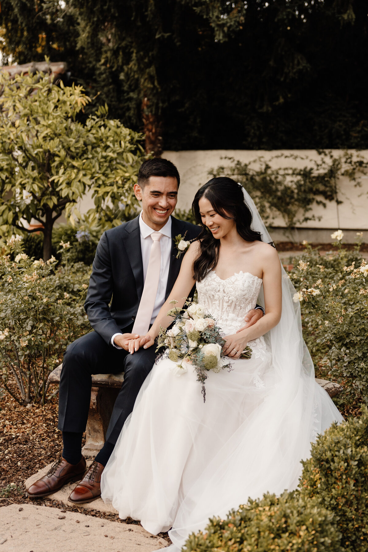 bride and groom sitting with bouqet