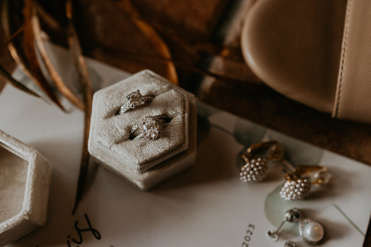 flatlay of a LGBTQ+ couples wedding details and jewelry