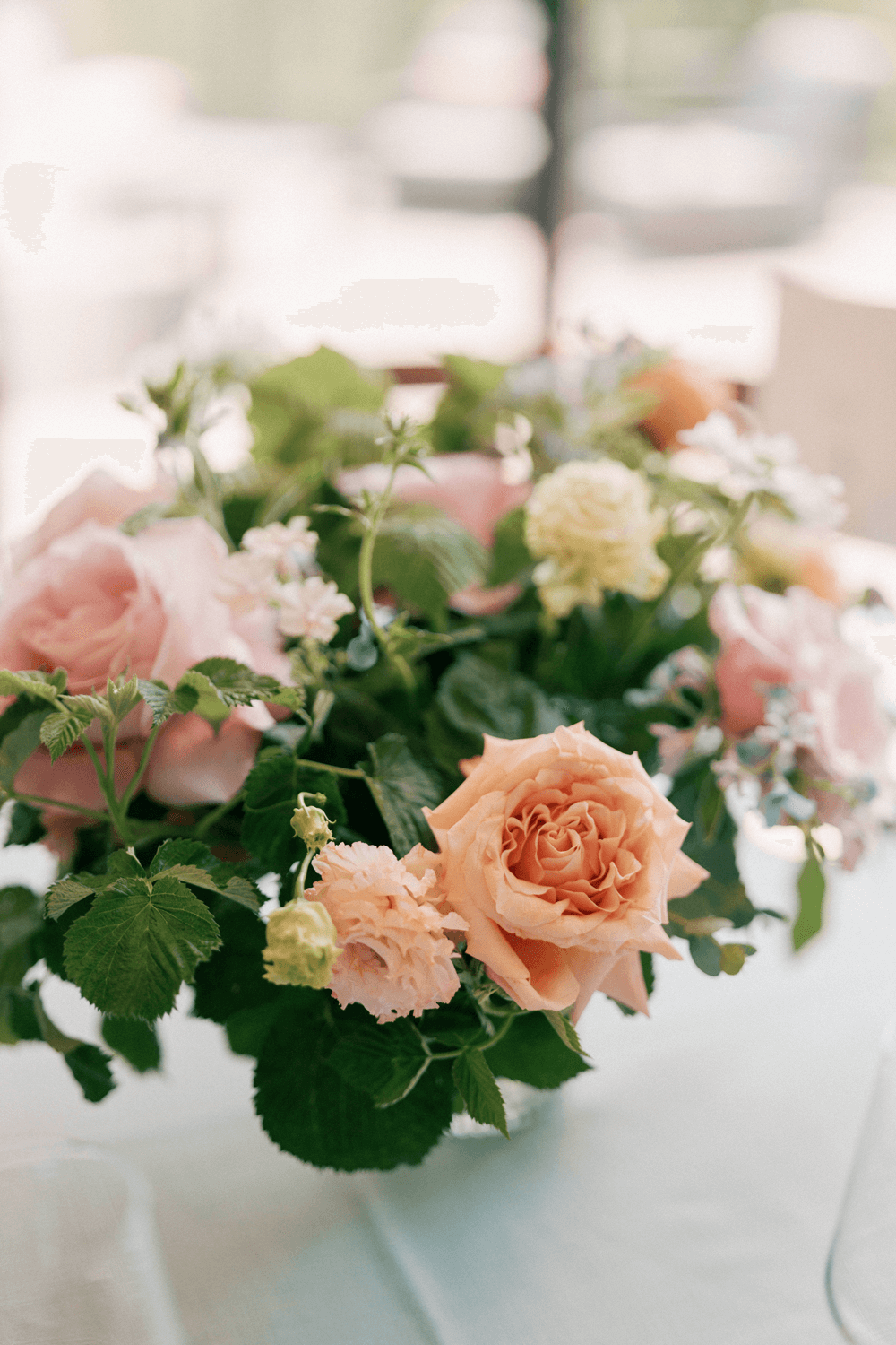 Pastel floral arrangement of blush garden roses and soft greenery for a summer wedding reception at Moonlight Basin, designed to reflect a Mountain Luxury meets Garden Party wedding theme.