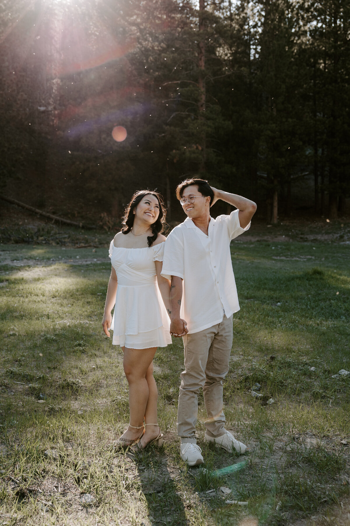 A couple stands back to back while smiling at each other at Mt Charleston.