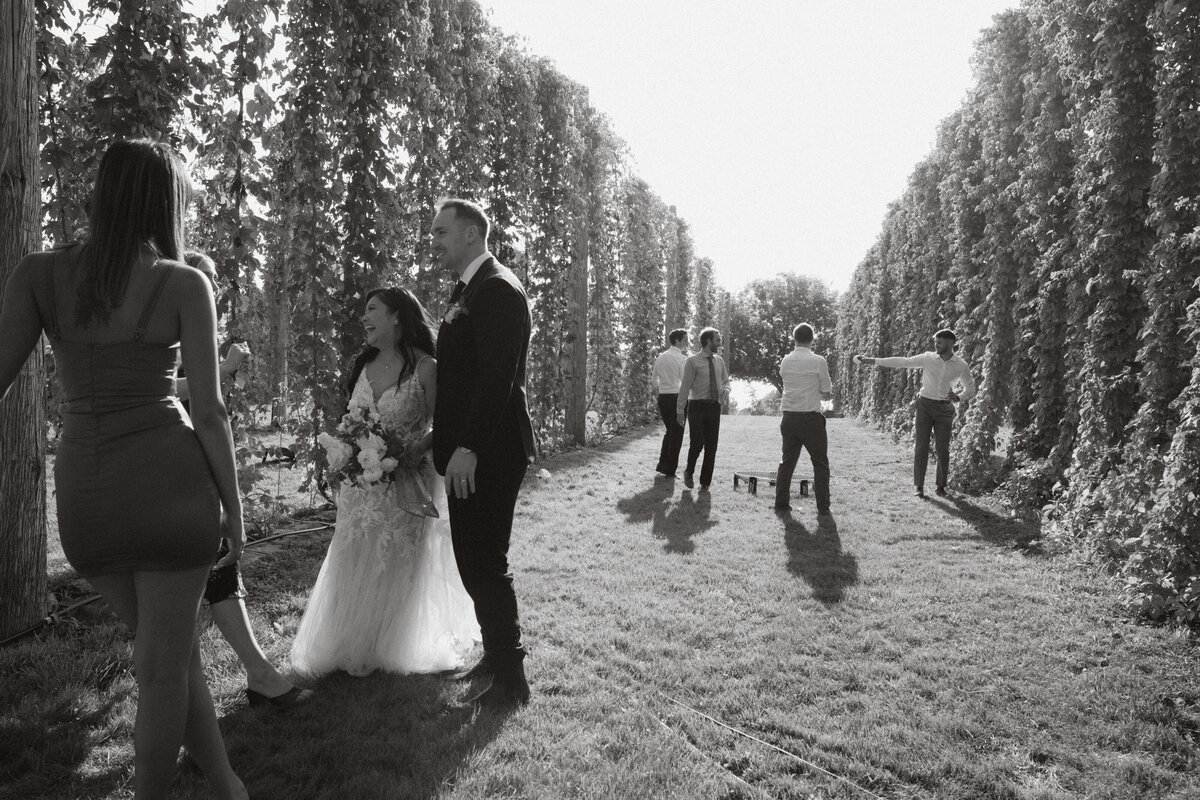 the newlyweds mingle with guests while games in nature happen behind them