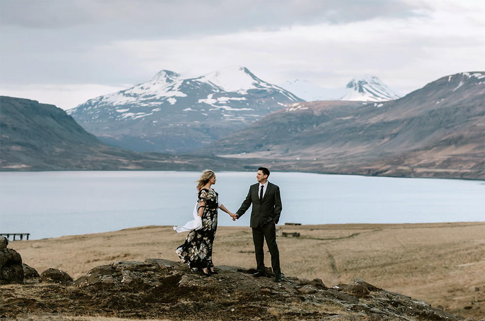 couple is posing in front of a mountain in Iceland