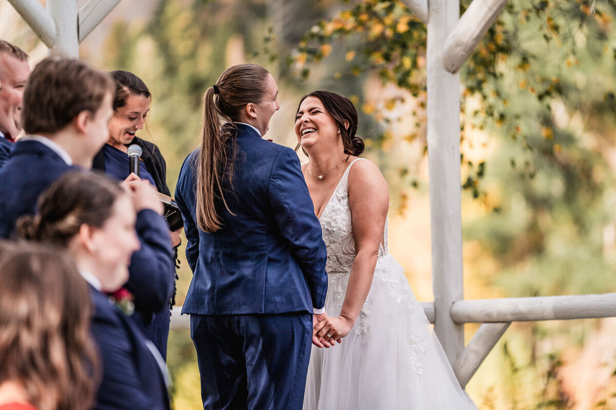 Brides sharing a joyful moment in ceremony at Waterville Valley Resort wedding by Lisa Smith Photography