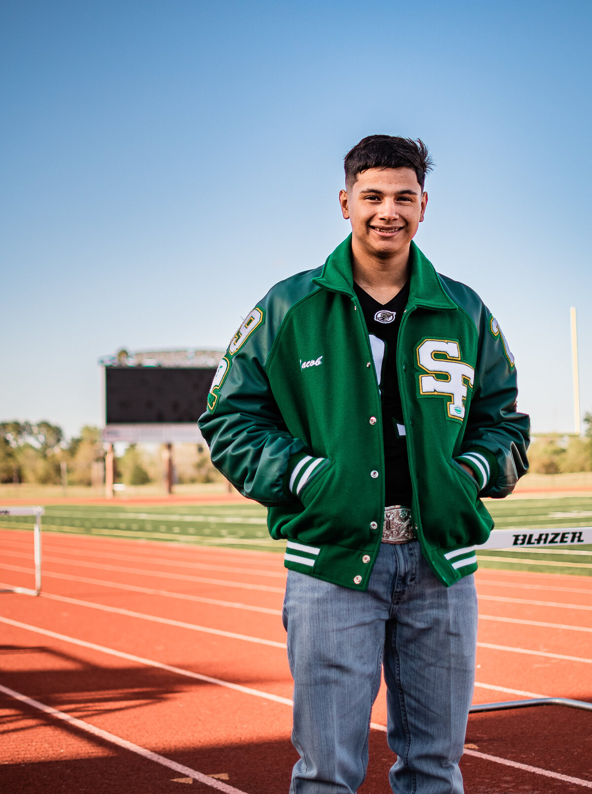 A Houston area senior wears his letterman on the track at his school.