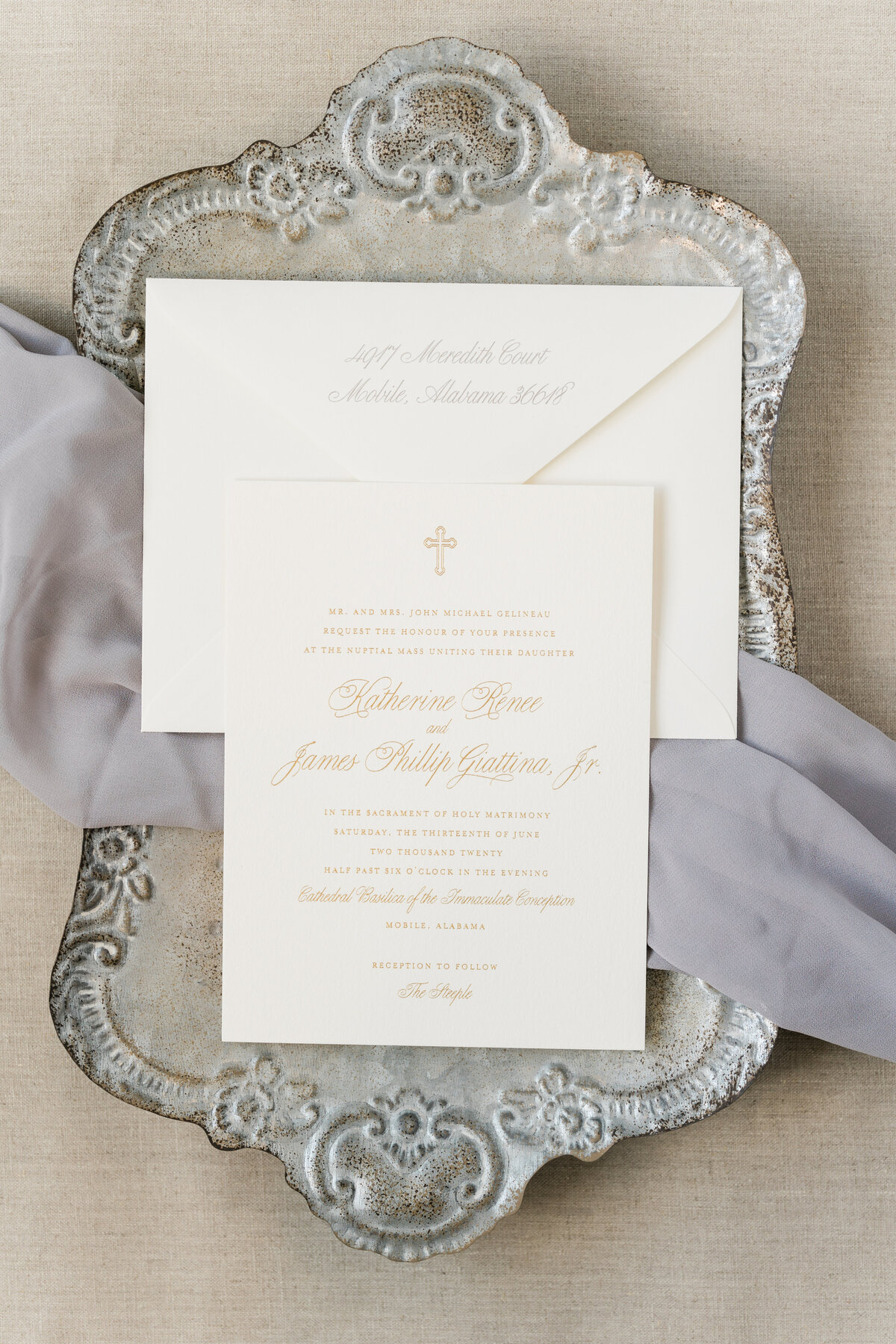 White and gold wedding invitations on silver platter