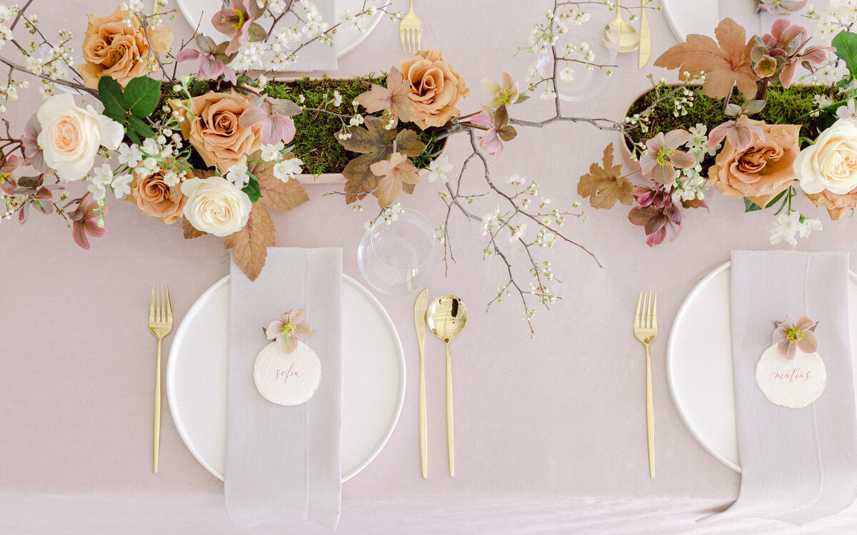 Lush, pastel spring flowers form a long, low table centrepiece at a Montreal wedding.