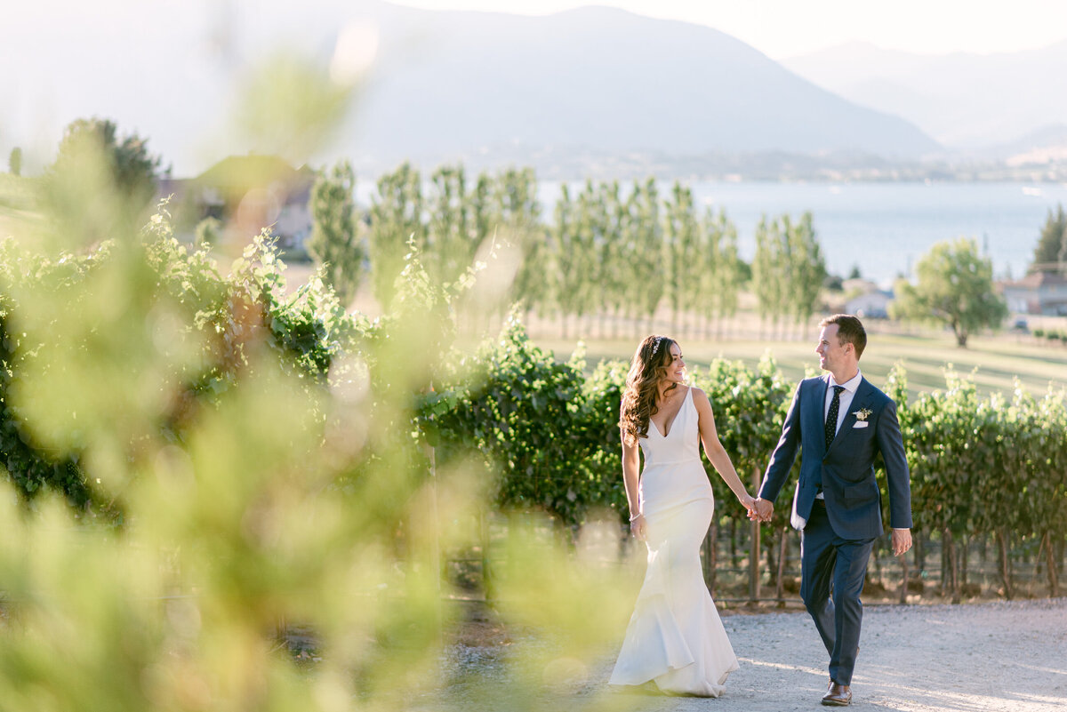 Bride and groom walking in vineyard at Tsillan Cellars wedding