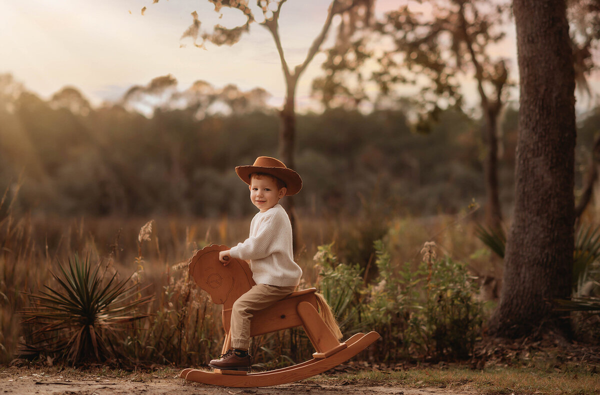 Baby rides a rocking horse during Family Photos on Kiawah Island.