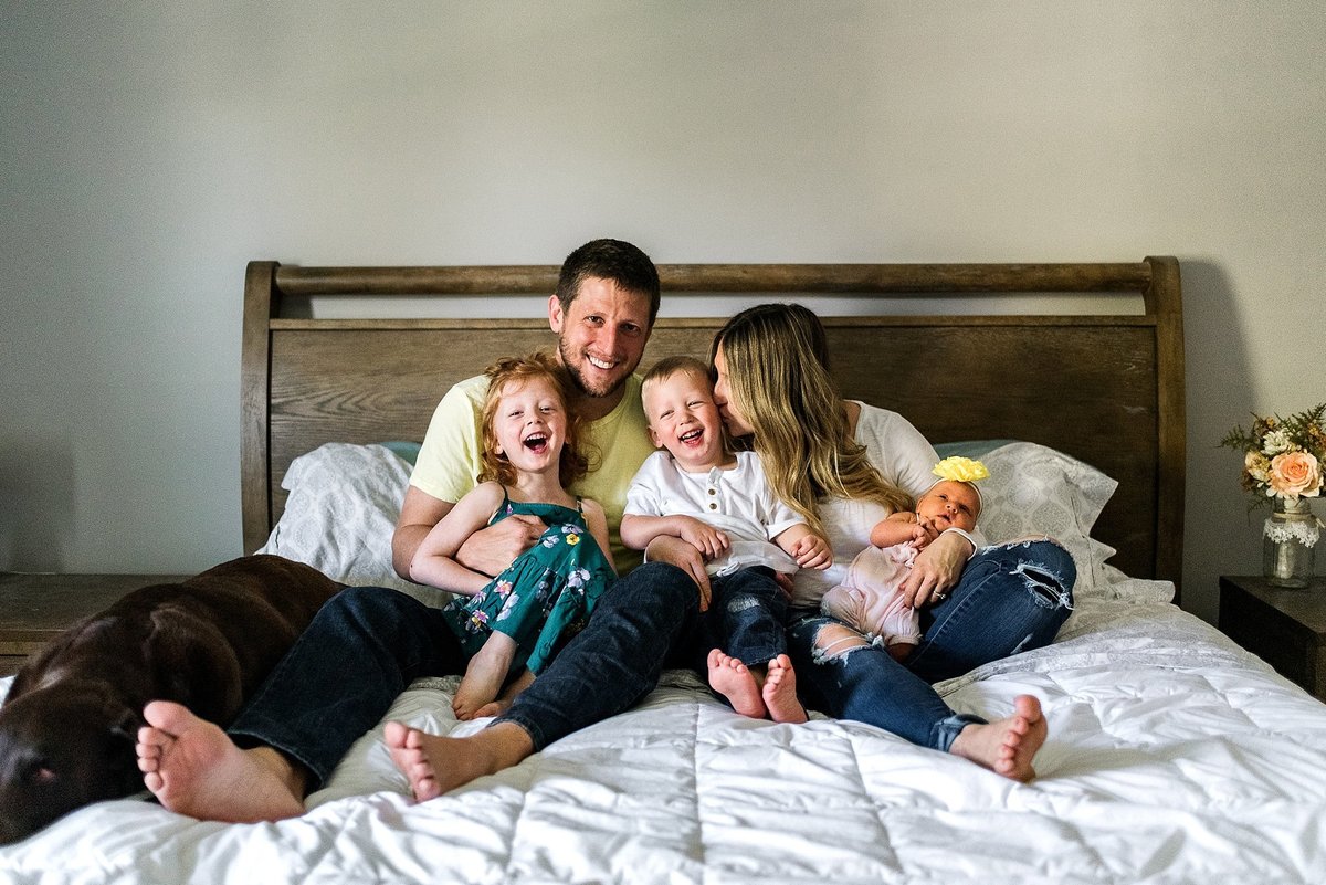 family with newborn on parent's bed