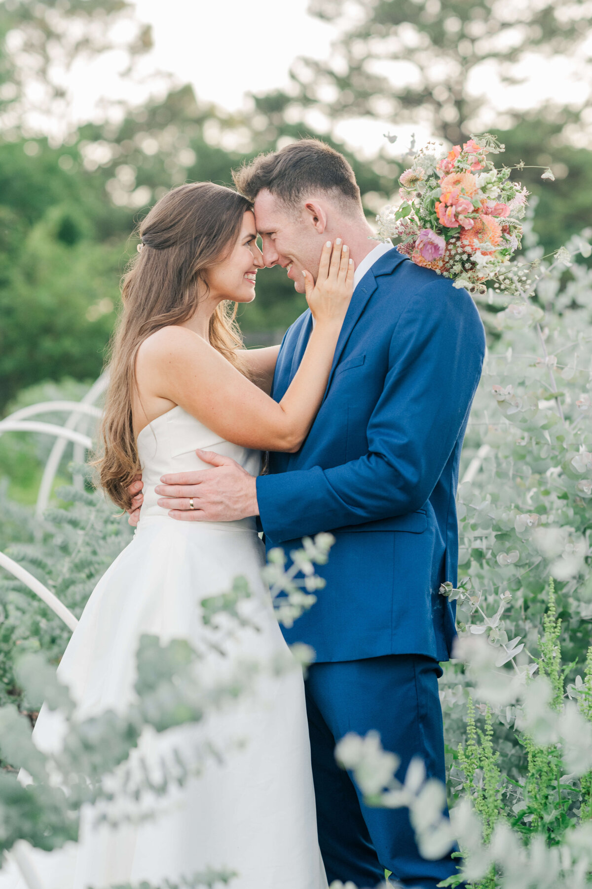 Alabama bride and groom holding each other in a field of greenery