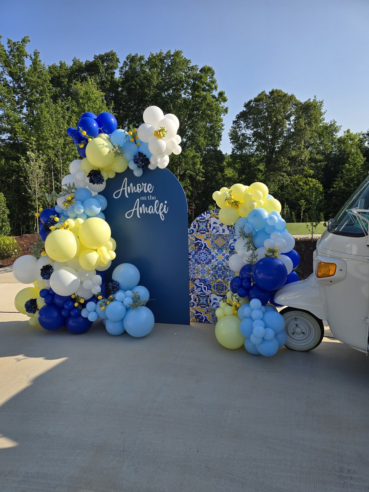Blue and yellow balloon backdrop setup for events by Air with Flair Decor, Raleigh Balloons and Event Rentals expert.