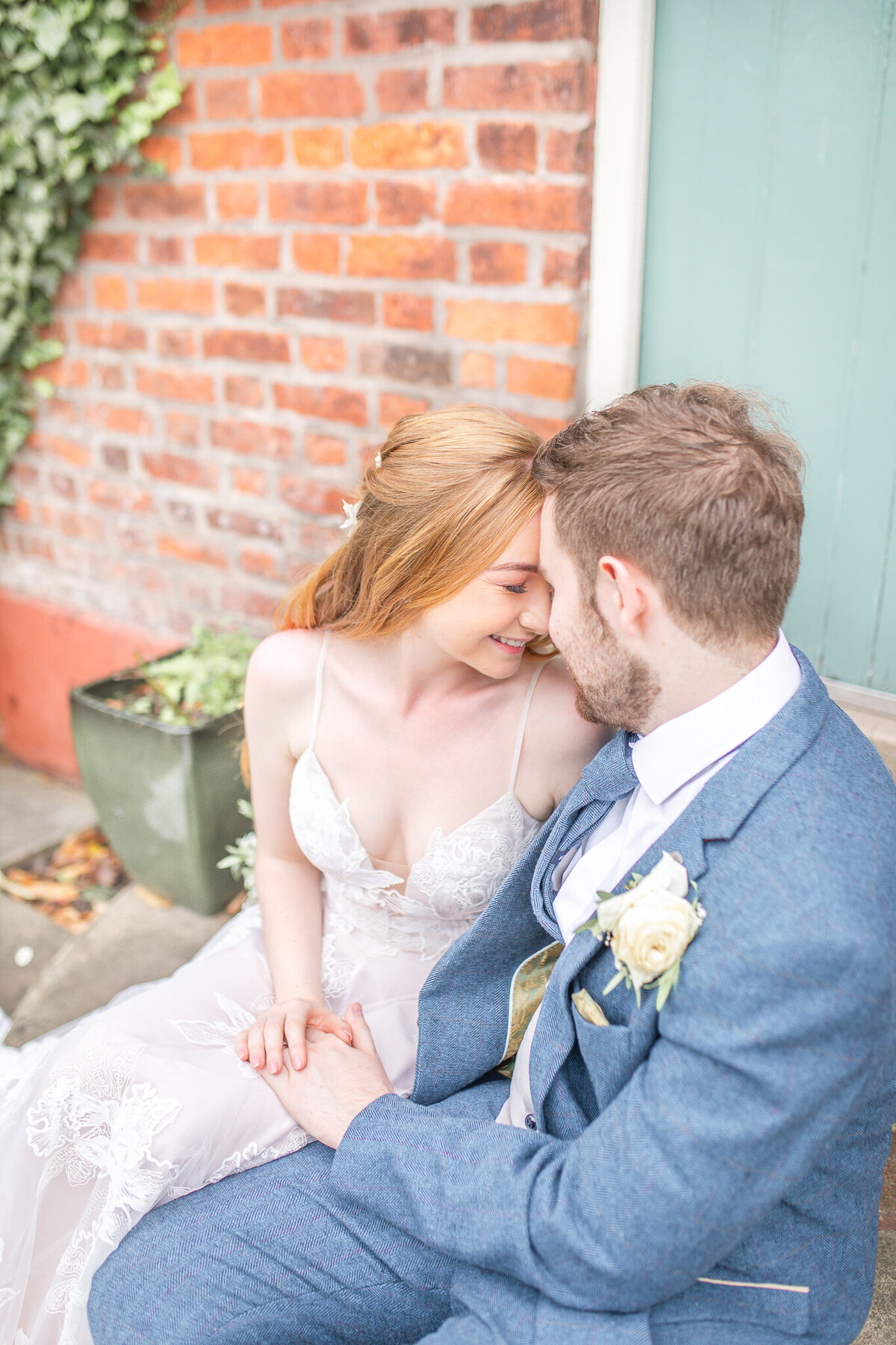 Close up of bride and groom sitting on the steps at The Plough Inn Congleton