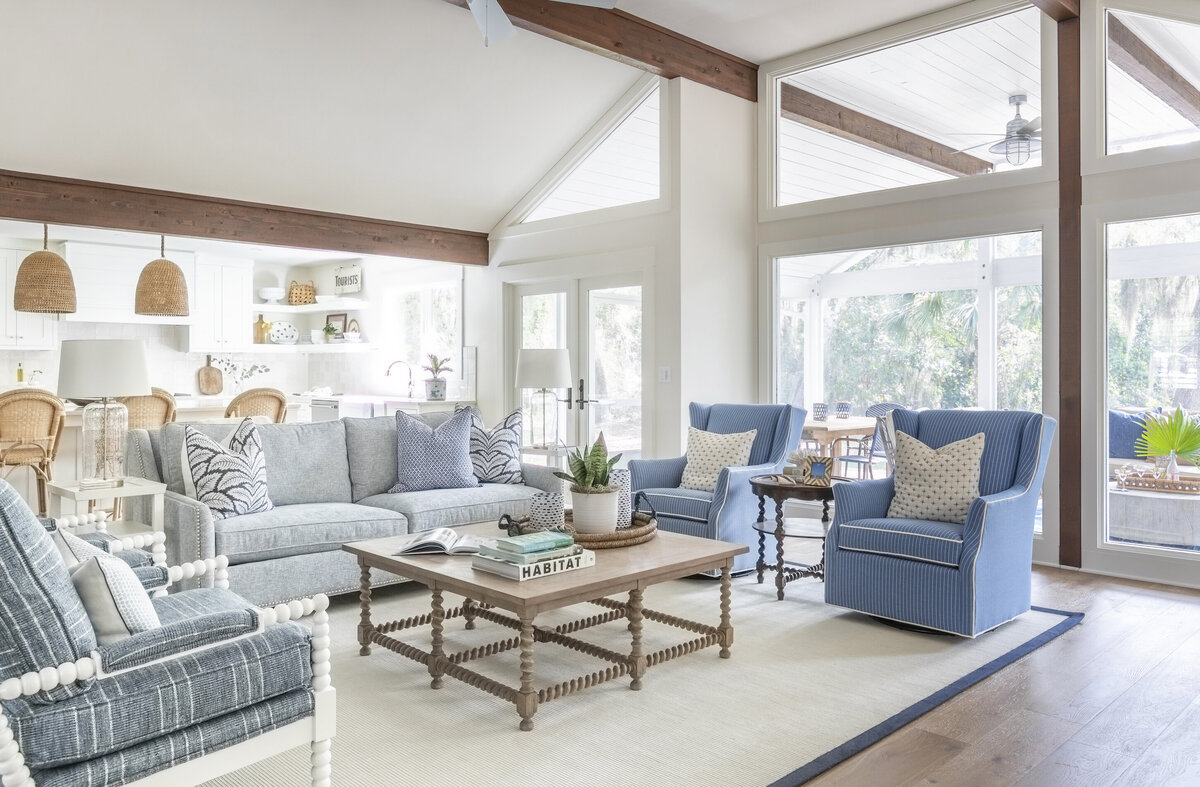 A bright living room with blue couches and exposed wood beams