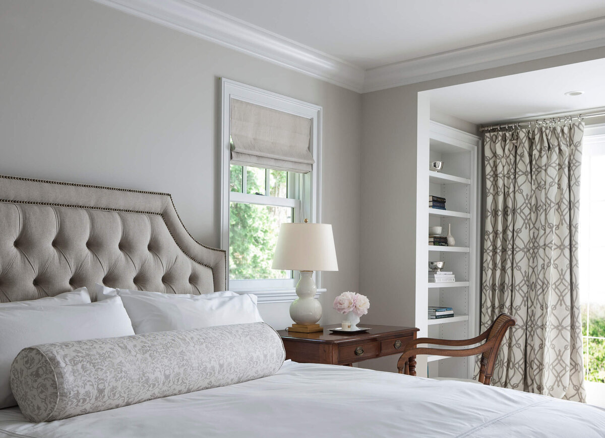 Tufted-headboard-antique-wooden-writing-desk-at-bedside