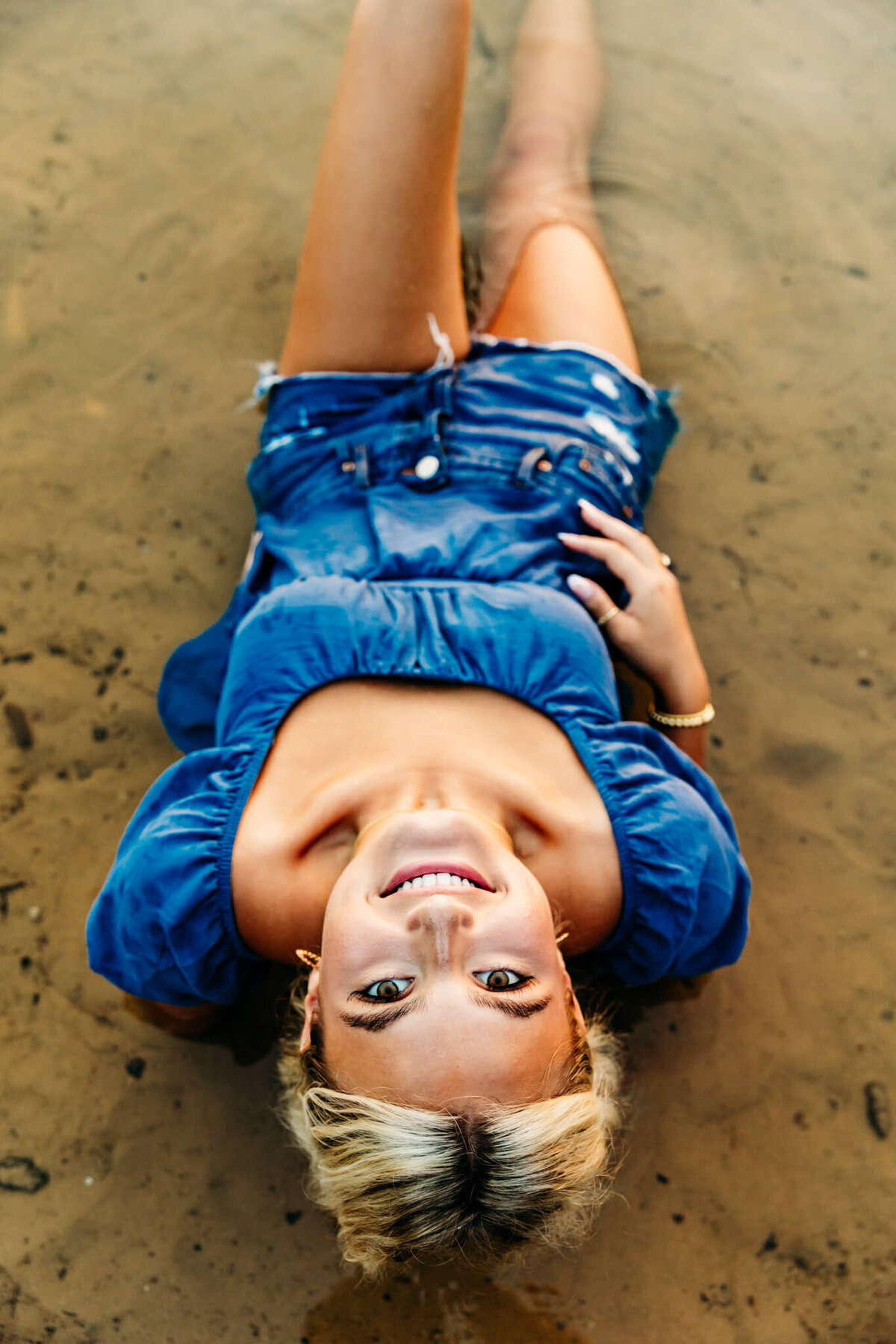 image of a female high school student laying back in the water and looking up captured by Ashley Kalbus Photography