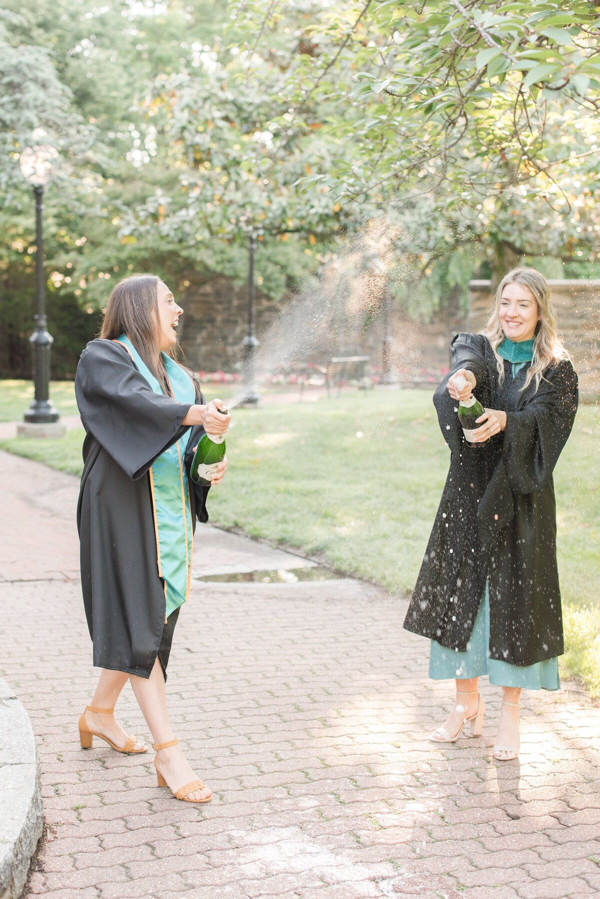 graduate sisters popping champagne