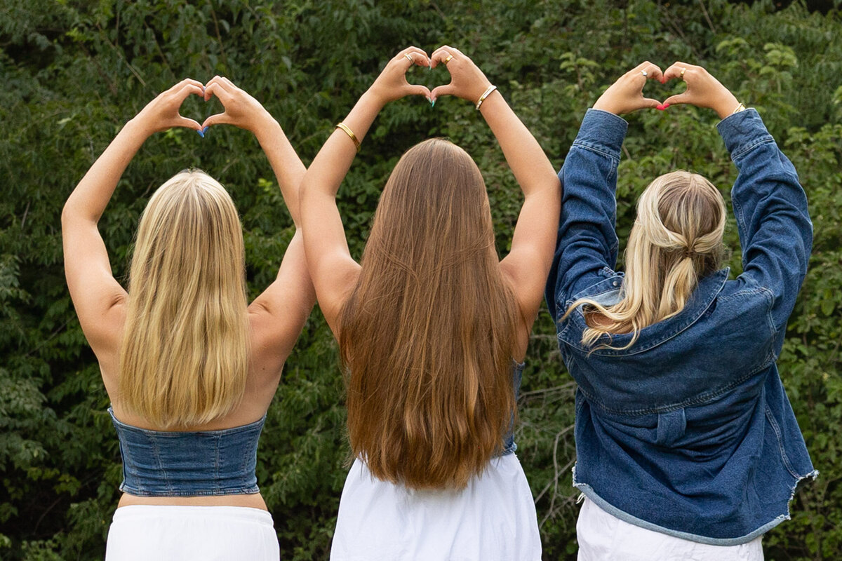MBP Senior Team holding up hearts with their backs turned to the camera in Lawrence, KS