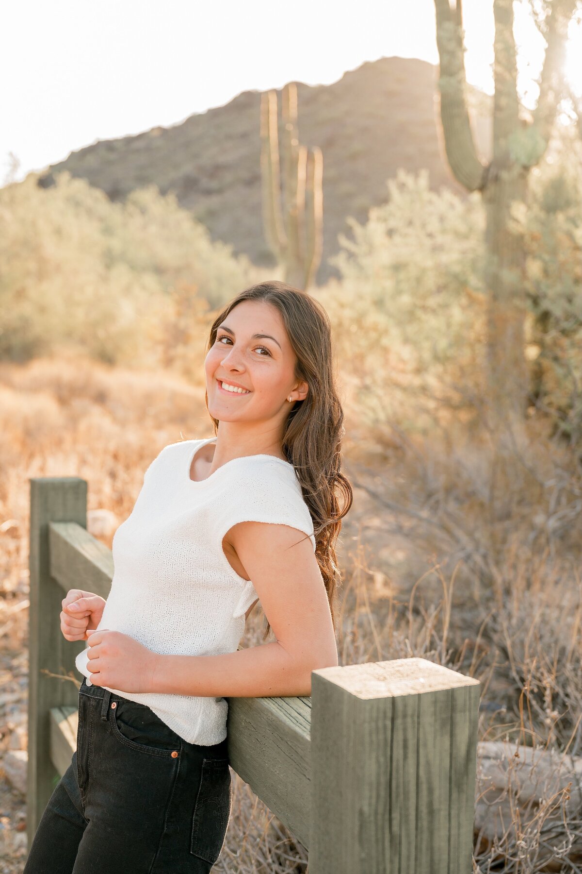 senior girl in white top with north scottsdale desert behind her 
