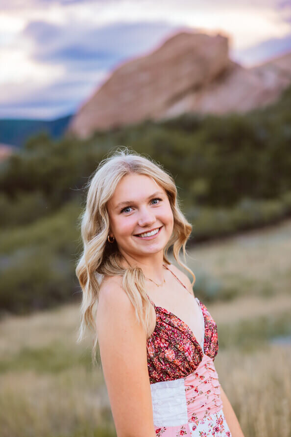 Close up of girl with greenery behind her.