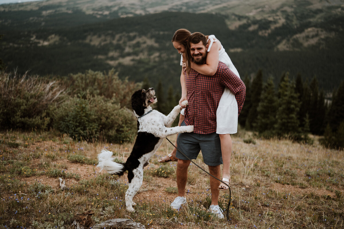 Playful couple with dog during a Hoosier Pass engagement shoot in the mountains.