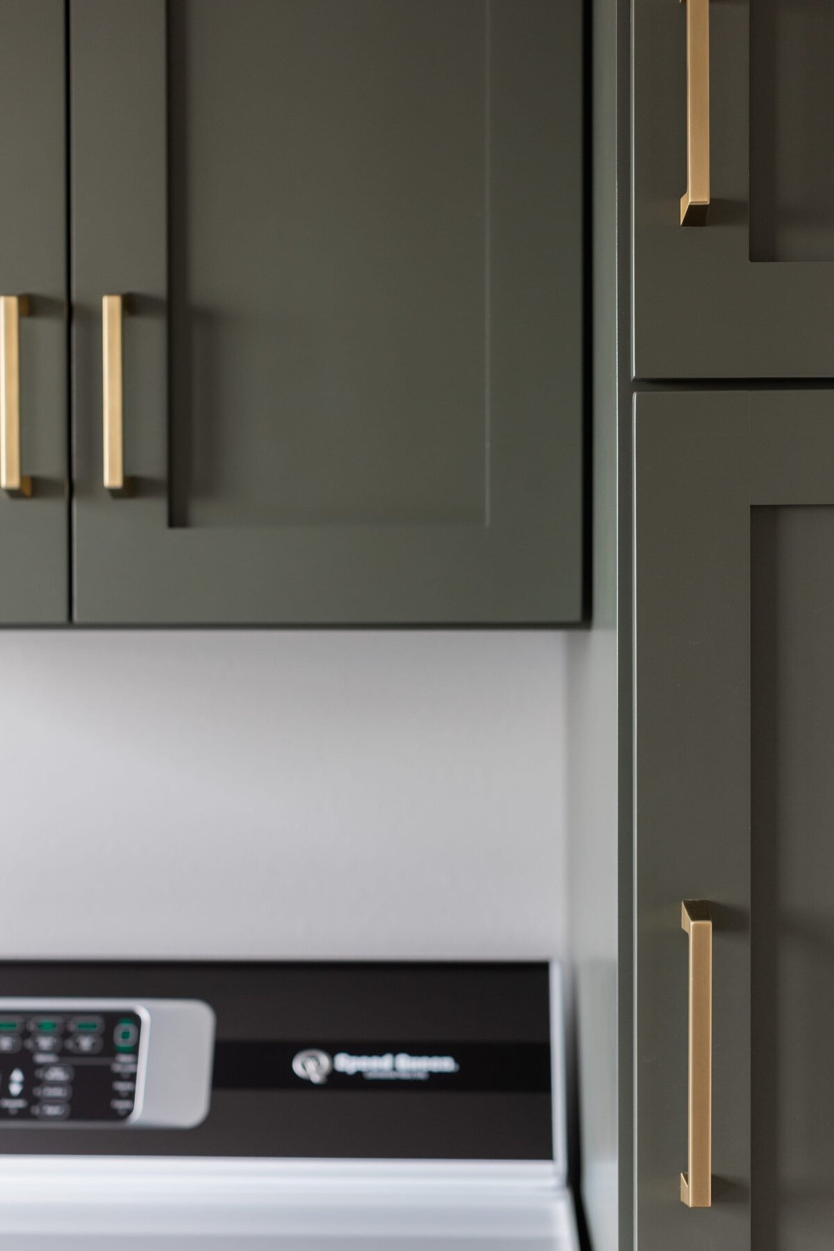 michele rosenboom design modern farmhouse green laurdry cabinets and gold handles