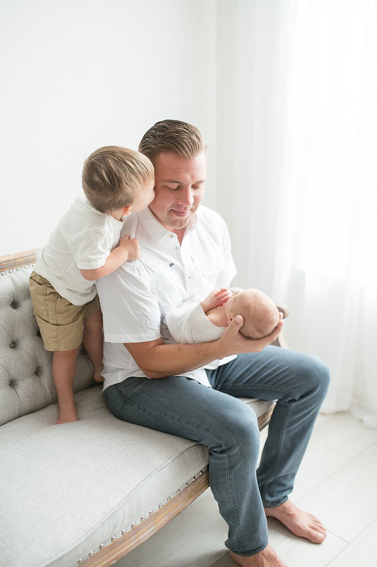 Dad and little boy, holding newborn baby during a Dallas Newborn Photography photoshoot